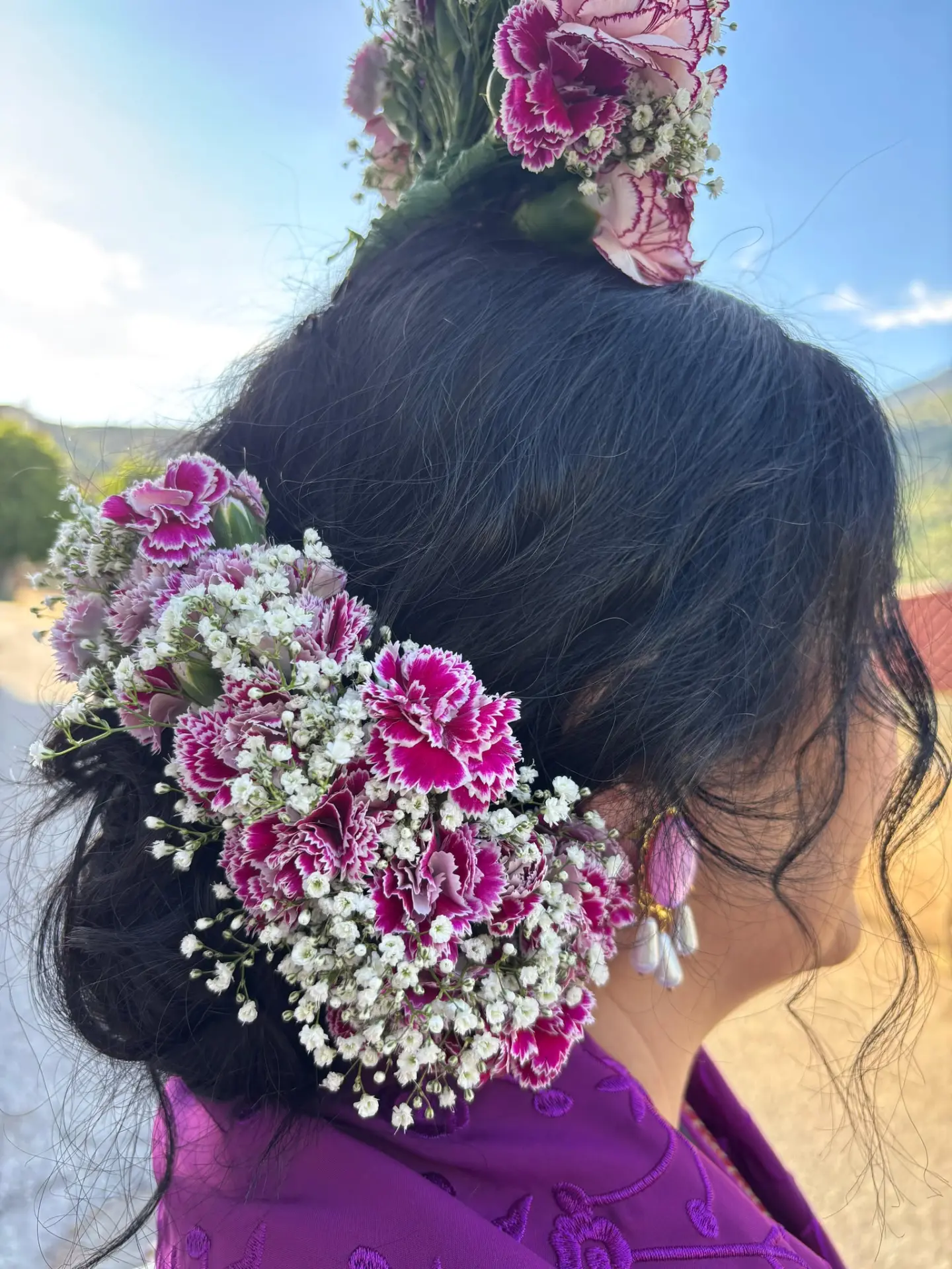 Tocado floral de claveles y paniculata en un recogido